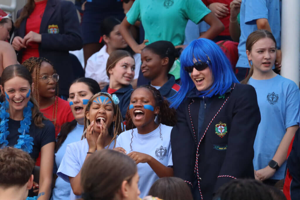 Crowd Of Students Watching And Cheering At Swim Gala.